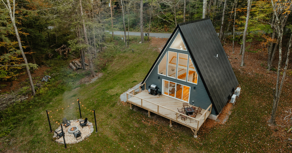 Bright, modern tiny home interior with space-saving hacks: built-in sofa storage, loft bed, floating shelves, and vertical wall storage.